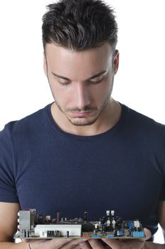 Confused, puzzled computer technician, a handsome young man, looking at motherboard