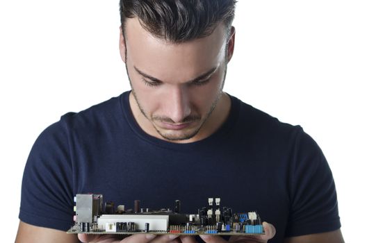 Confused, puzzled computer technician, a handsome young man, looking at motherboard