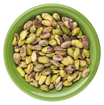 a small bowl of raw shelled pistachio nuts isolated on white,