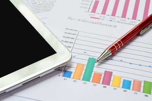 Tablet-pc, papers and red pen on business table