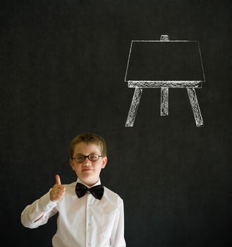 Thumbs up boy dressed up as business man with learn art chalk easel on blackboard background