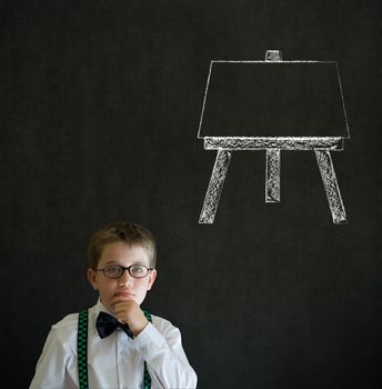 Thinking boy dressed up as business man with learn art chalk easel on blackboard background