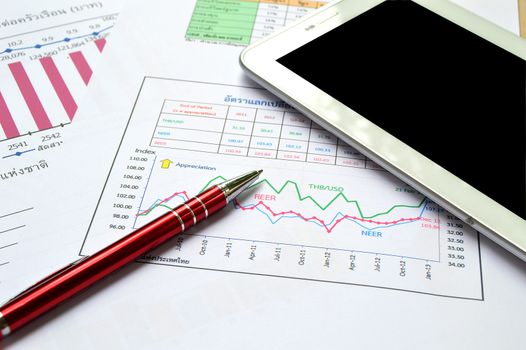 tablet-pc, papers and red pen on business table