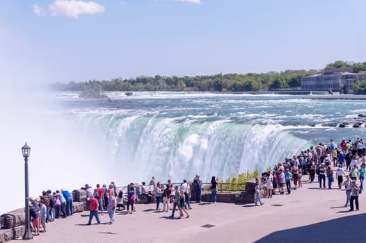 Niagara, Canada - May 16, 2013: Looking at Canadian side of the Niagara Falls on a sunny day. Tourists from all over the world are coming to see the waters falling off.