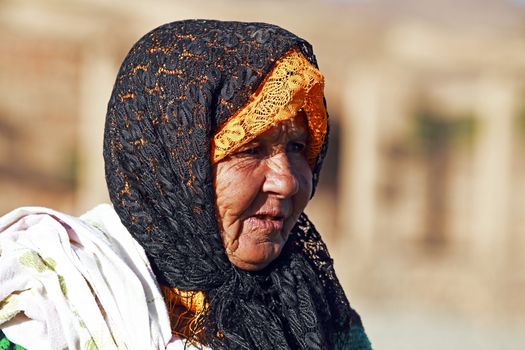 SAHARA DESERT, MOROCCO 19 OCTOBER 2013: Old nomad woman in the Sahara desert, Morocco. Nomadic tribes living in the desert, and a traditional lifestyle as a hundred years ago.