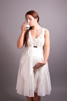 portrait of pregnant woman with glass of milk