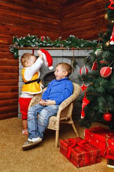 Two brothers near decorated Christmas tree pending holiday