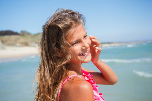 Closeup portrait of young beach girl on blue sea shore in summer vacation