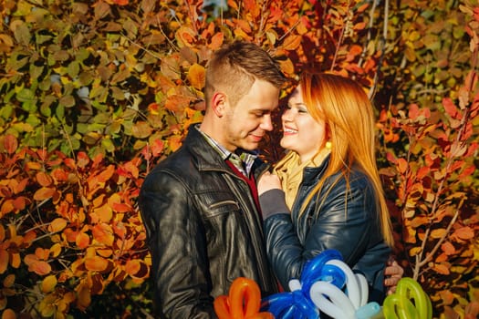 Young couple tenderly and lovingly looking at each other in autumn park