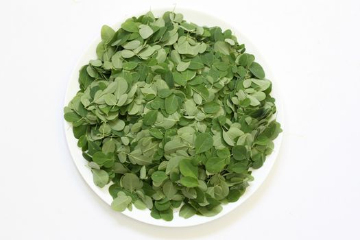 Moringa Oleifera leaves arranged in a plate with background