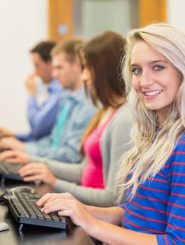 Side view of young students using computers in the computer room