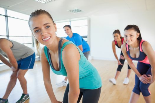 Portrait of fitness class and instructor doing power fitness exercise in fitness studio