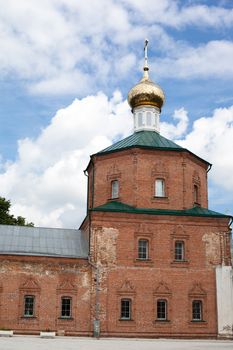 Brick red orthodox church with one golden dome
