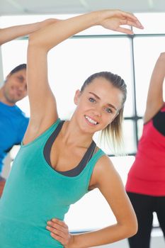 Portrait of smiling people doing power fitness exercise at yoga class