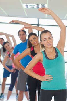 Portrait of sporty people doing power fitness exercise in row at yoga class