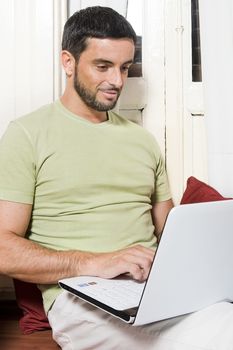 Happy Young Man Working on Laptop at Home 