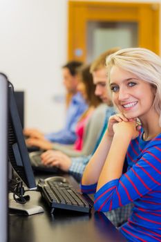 Side view of young students using computers in the computer room