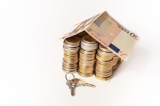 Euro Coins pile House with banknote roof and key isolated on white background