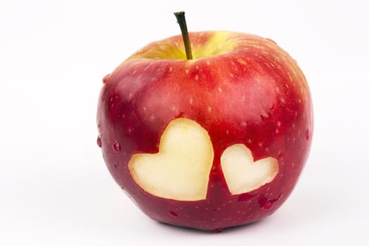 Two hearts on the fresh apple, a Valentines Day theme, on a white background.