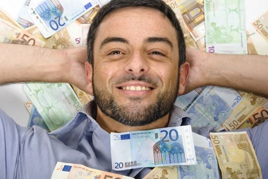 Happy Young Man with Beard laying on Banknotes isolated