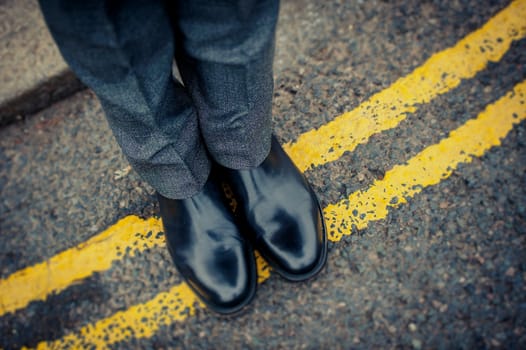 Londoner on immaculate shoes on a street road yellow line