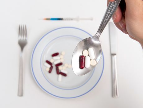 Medical Soup of pills Man holding spoon full of tablets