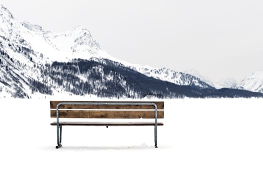 Wooden bench on a snowy winter landscape
