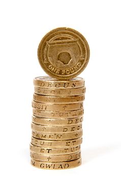 A stack of one pound GBP coins with one facing towards the camera
