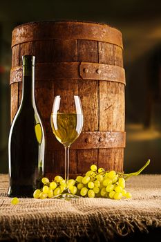 vine composition old barrel with wineglass bottle and winegrape on table