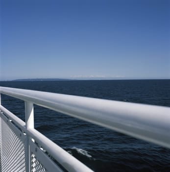 White metal railing against the blue ocean