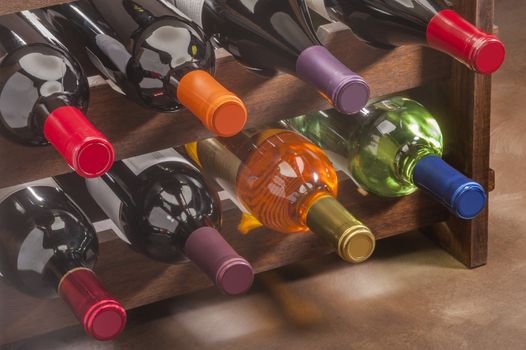 wine bottles stacked in a rack with colorful foil necks
