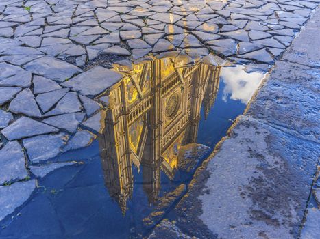 Reflection of the Orvieto cathedral in a water puddle, Tuscany, Italy
