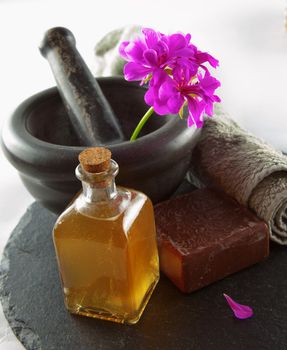 Soap, oil, flower and mortar over black stone