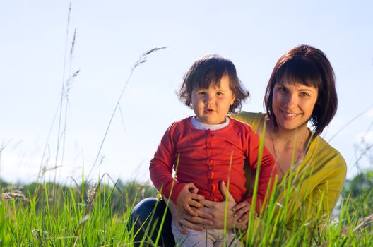 Young woman with small daughter outdoor on sunny day