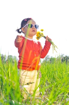 Little girl in sunglasses on meadow