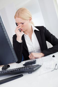 Cheerful young businesswoman with headache working in the office