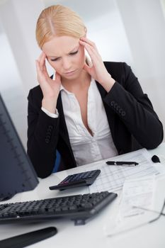 Cheerful young businesswoman with headache working in the office