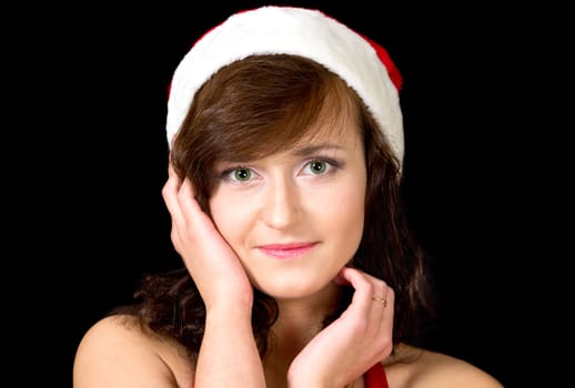 Portrait of young woman in santa hat isolated on black