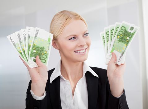 Businesswoman holding euro currency notes in the office