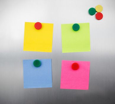 Coloured notes and magnets on inox metallic fridge