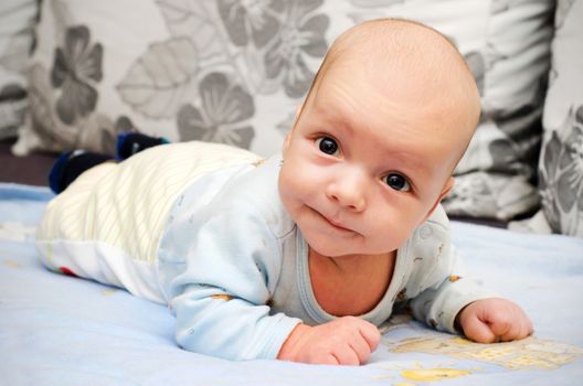 Little newborn baby boy lifting head