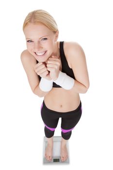 Fitnesswoman standing on weights. Isolated on white