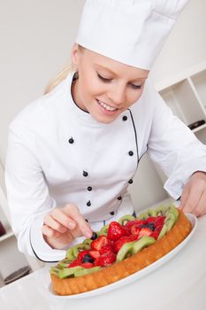 Beautiful chef woman making cake in the kitchen