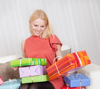 Beautiful young woman with her presents on the sofa
