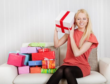 Beautiful young woman with her presents on the sofa