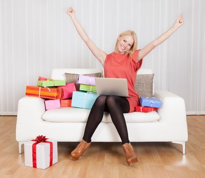 Beautiful young woman buying presents in Internet