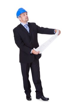 Happy Male Architect Looking At Blueprint On White Background