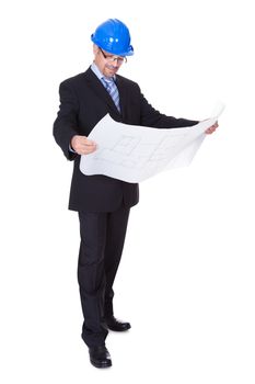 Happy Male Architect Looking At Blueprint On White Background