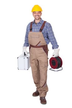 Happy Construction Worker Holding Toolbox And Cable On White Background