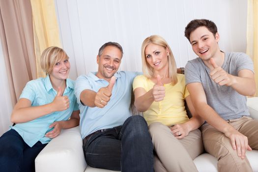 Smiling attractive young family with a teenage son and daughter posing together in group portrait